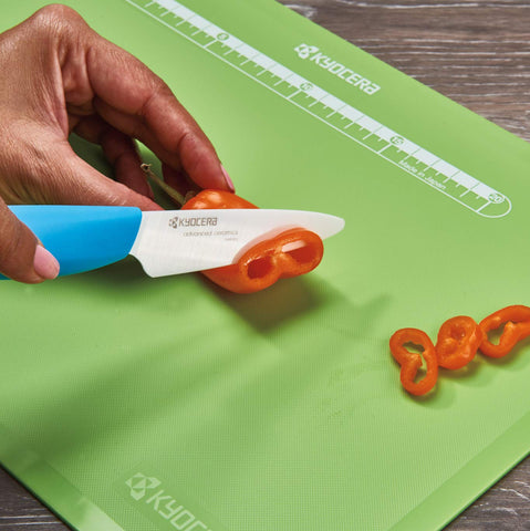 Kyocera Revolution 3-inch paring knife in use with fruits and vegetables for precise prep.