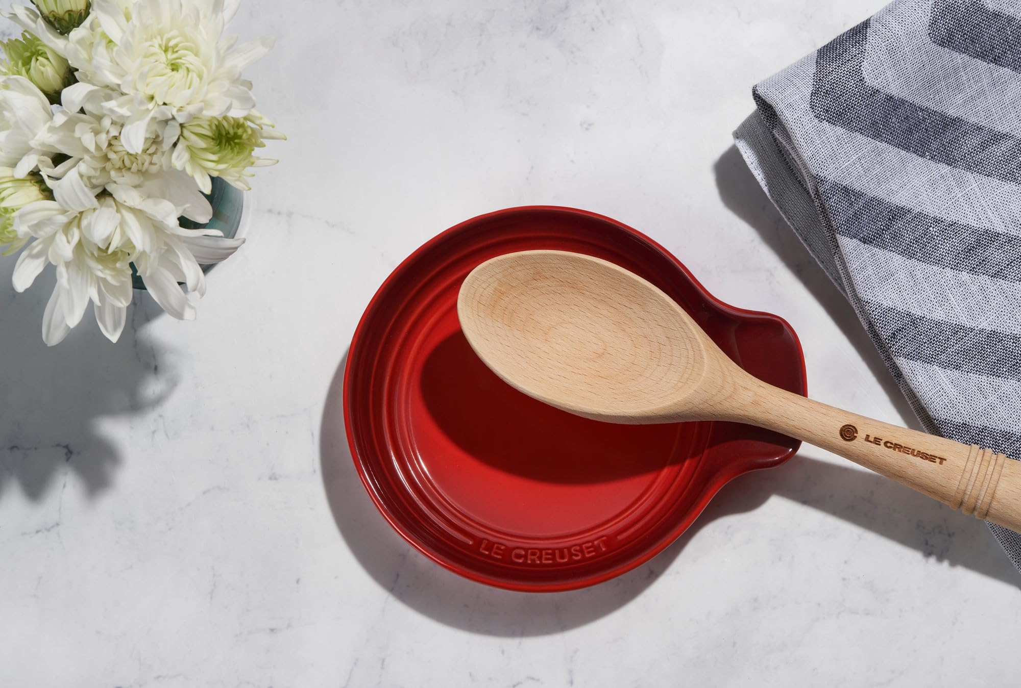 Le Creuset Artichaut spoon rest protects countertops while resting utensils.