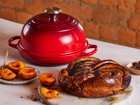 Le Creuset Bread Oven Cerise enamel finish resists staining and chipping for lasting beauty.