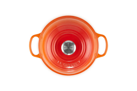Le Creuset Bread Oven Flame domed lid traps steam for bakery crust.
