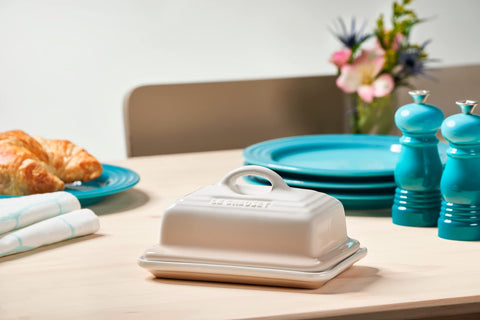 Le Creuset butter dish on table ready for serving.