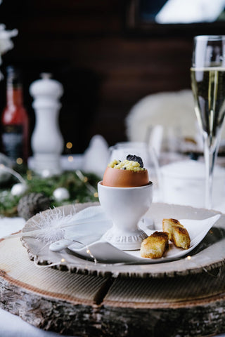 Le Creuset egg cup displayed with Easter eggs and herbs.