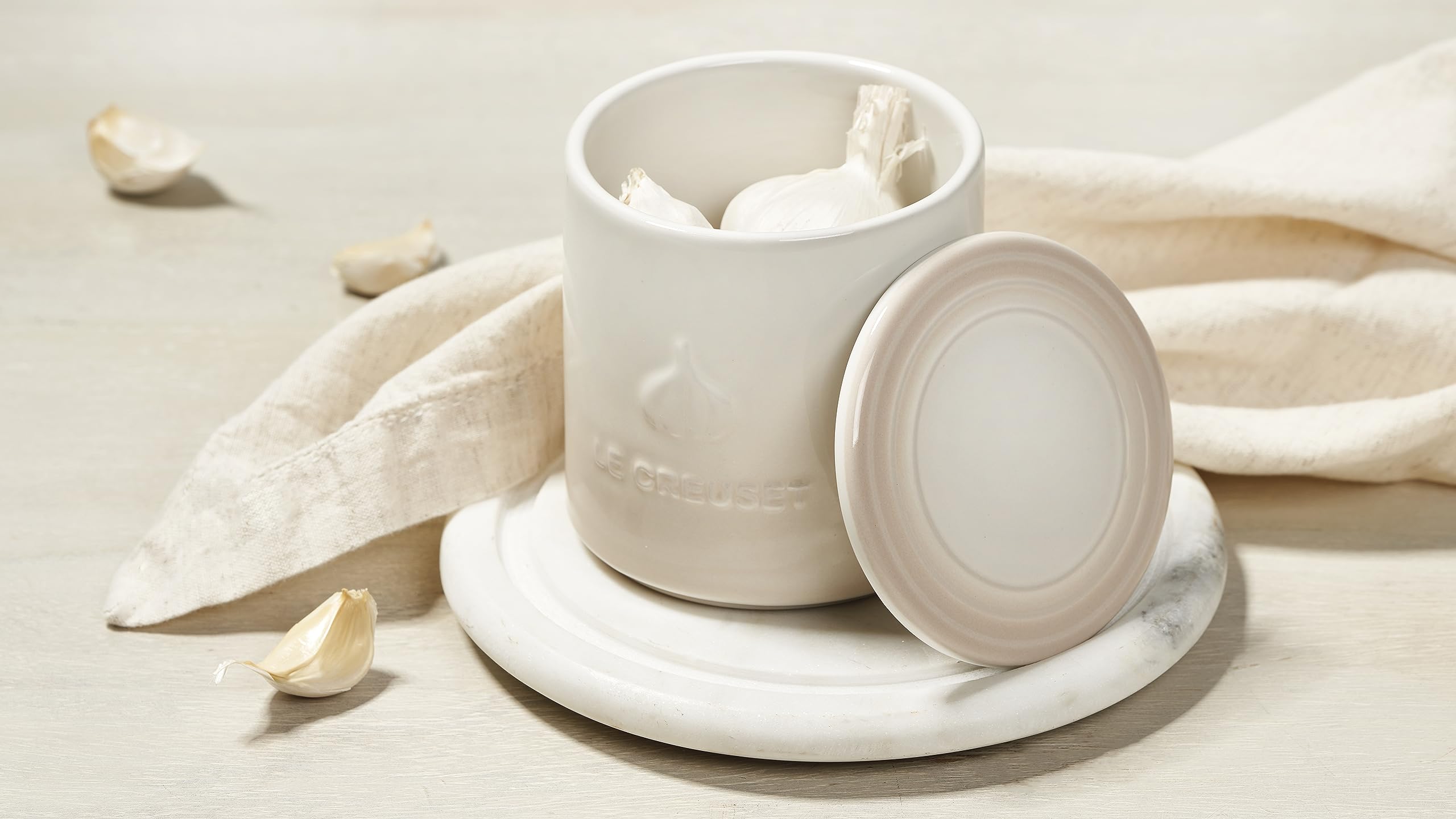 Dishwasher-safe Le Creuset garlic keeper shown for effortless cleanup after cooking.