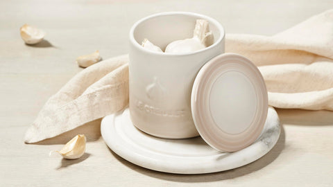 Dishwasher-safe Le Creuset garlic keeper shown for effortless cleanup after cooking.