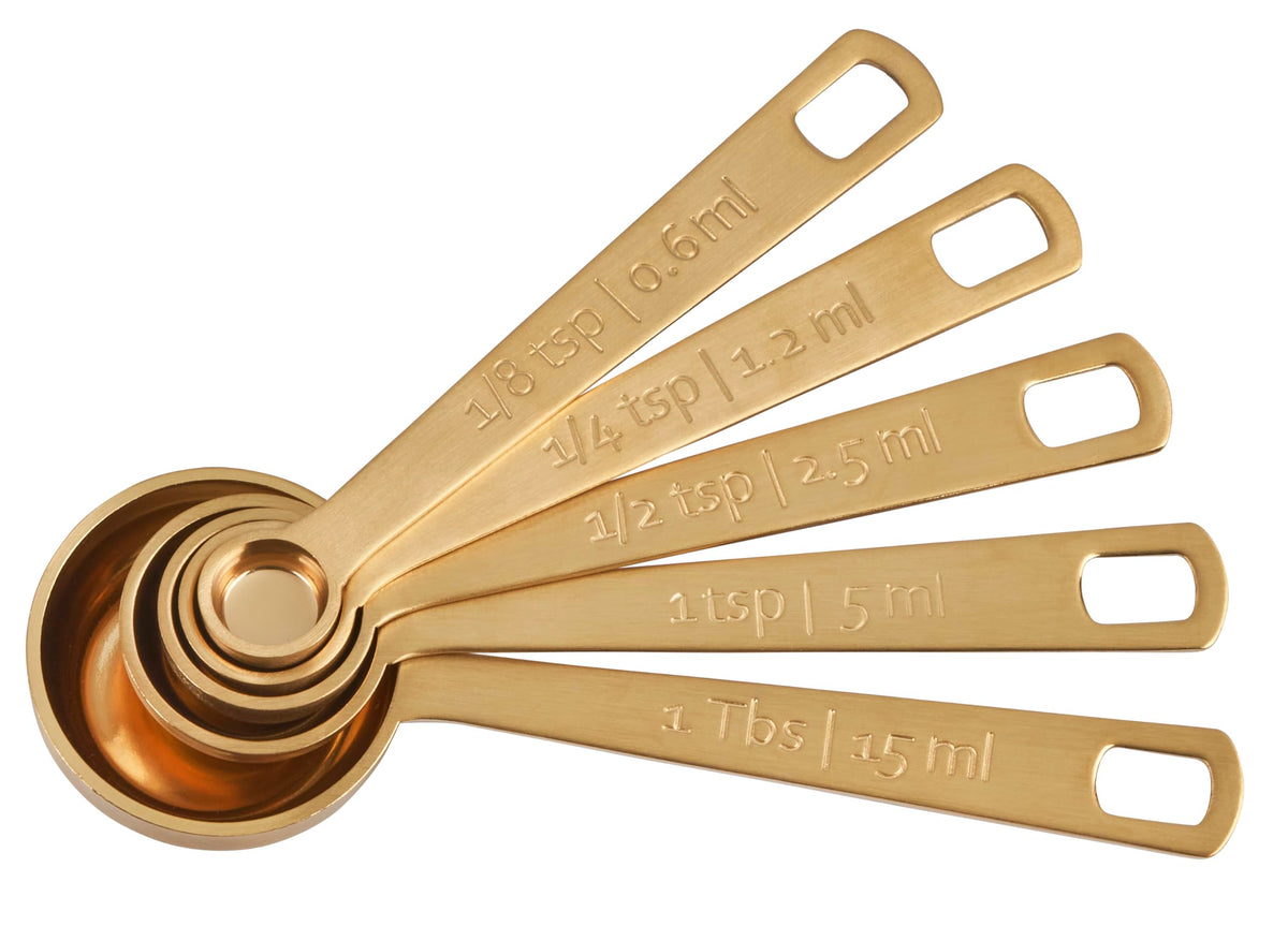Le Creuset gold measuring spoon 1/8tsp for precise spice measurements.