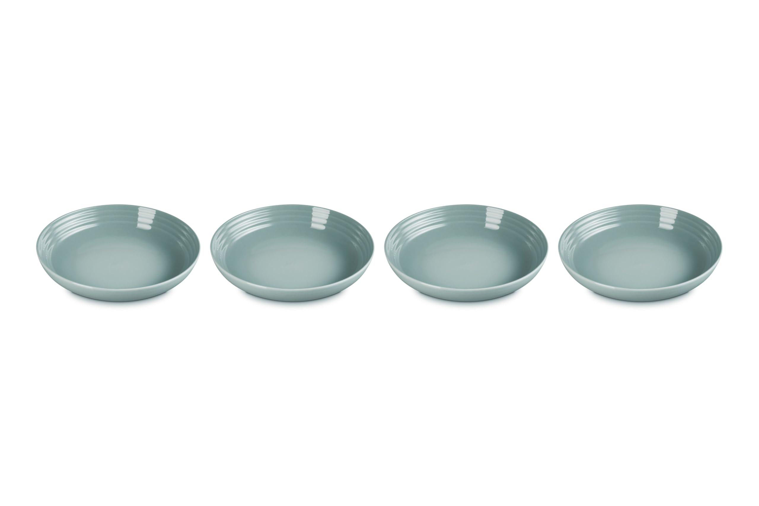 Le Creuset Sea Salt pasta bowls on table show vibrant color and sturdy construction for everyday meals.