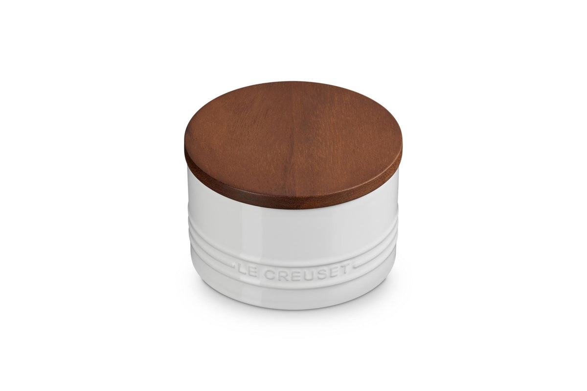 Le Creuset salt cellar with wood lid keeps salt fresh and organized on the counter.