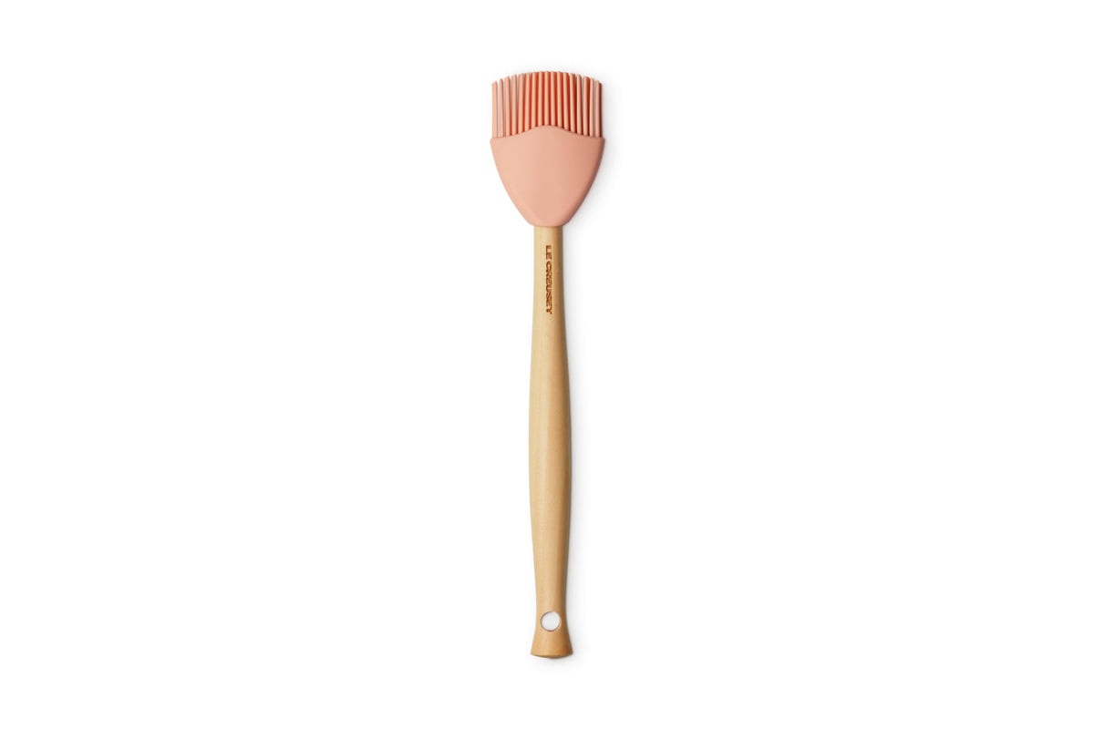 Le Creuset silicone craft basting brush in Peche with wood handle, ideal for sauces.