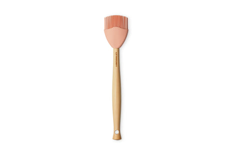 Le Creuset silicone craft basting brush in Peche with wood handle, ideal for sauces.