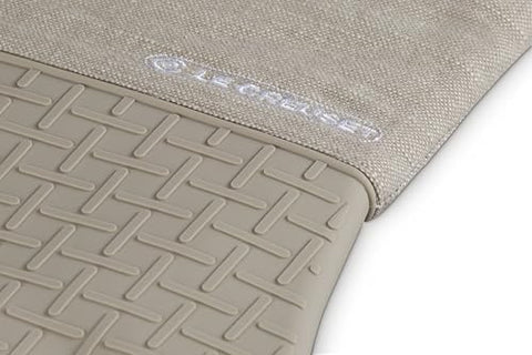 Le Creuset Textile Oven Mitt demonstrates silicone grip for secure handling.