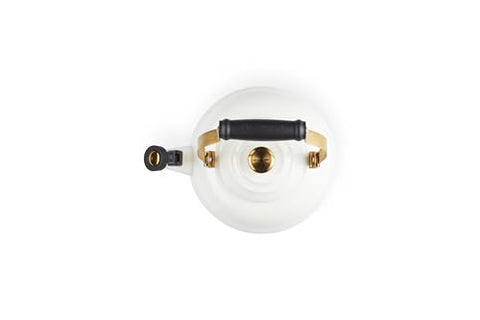 Close-up of Le Creuset kettle gold knob and brackets for secure handling.