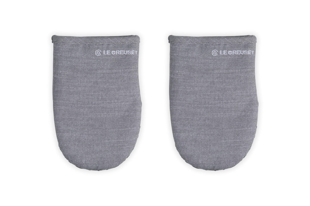 Le Creuset mini oven mitts grip hot handles securely for safe oven transfers.
