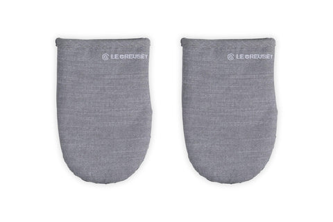 Le Creuset mini oven mitts grip hot handles securely for safe oven transfers.