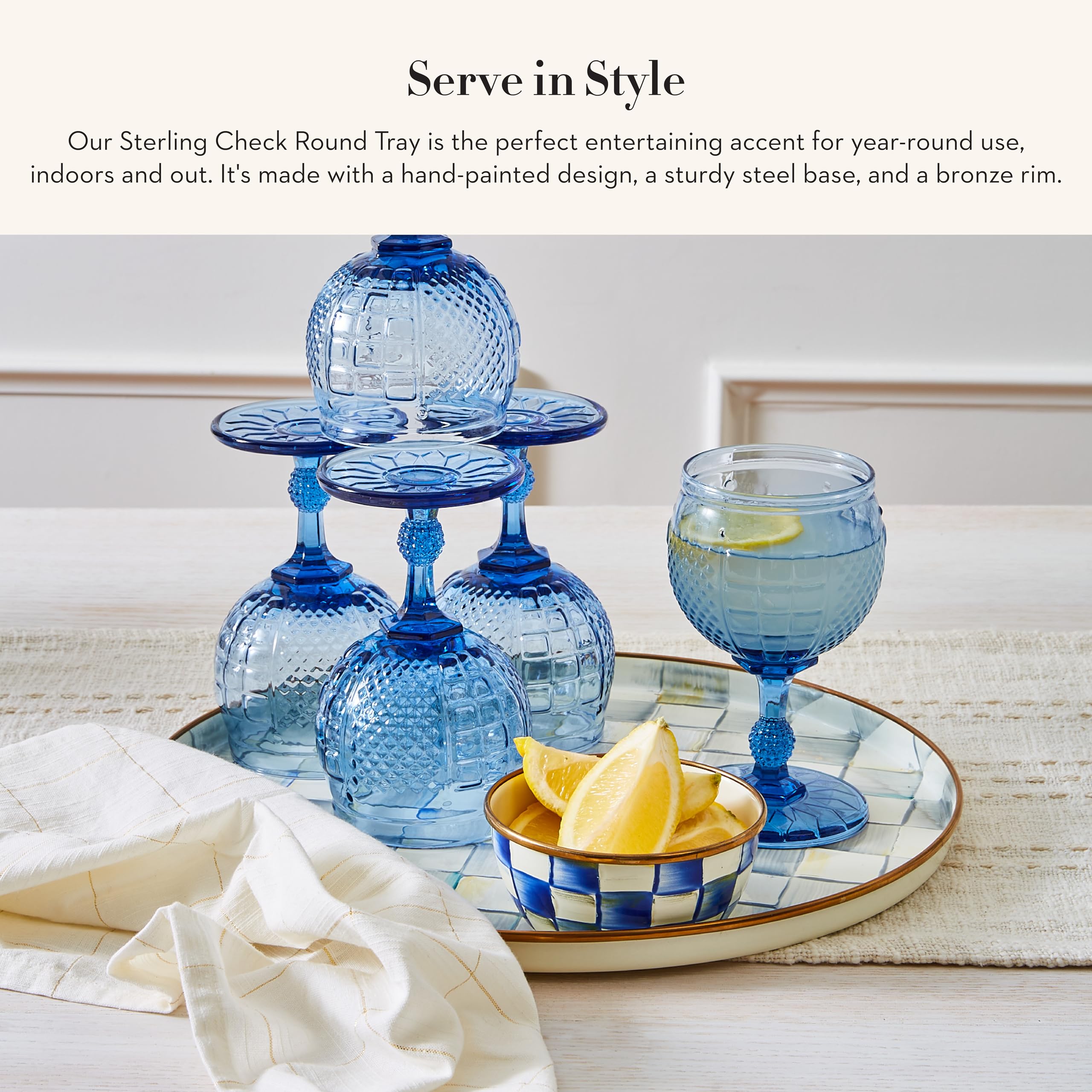 MacKenzie-Childs enamel round tray gray-white check enhances table decor.