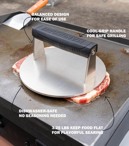 Manucode steak-weight press keeping meat flat for even cooking.