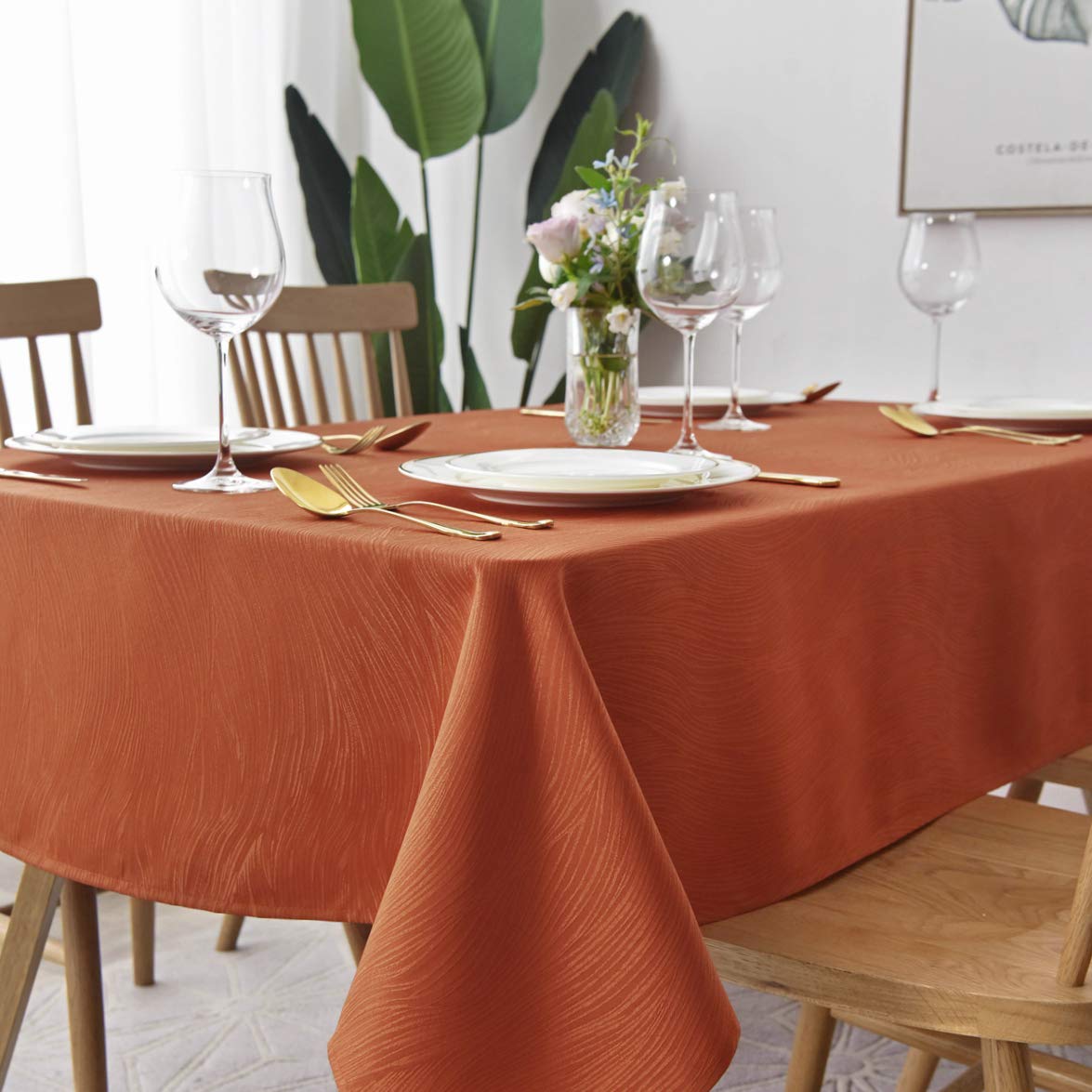 Maxmill Jacquard Swirl Rust tablecloth draped on a table highlights elegant dining mood