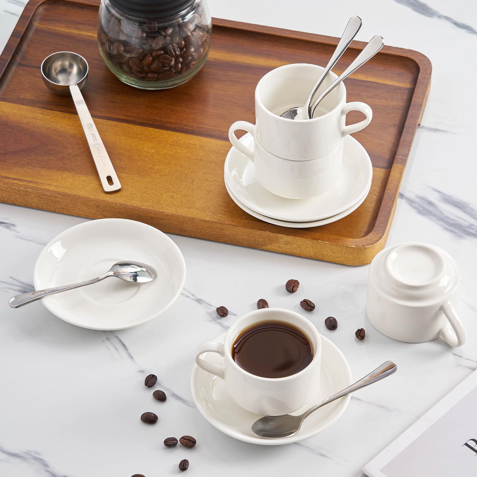 Meichu stainless steel spoons accompany porcelain cups for a refined table.