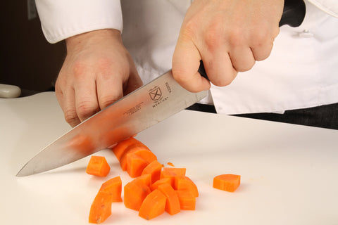 Mercer Culinary Millennia full-length knife in a professional kitchen setup.