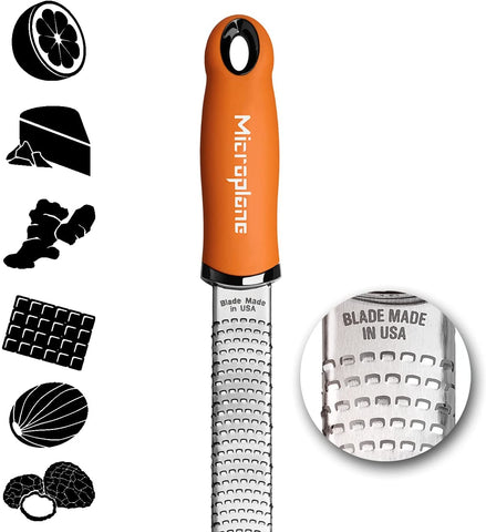 Microplane Premium Classic Zester Grater in action zesting citrus over a bowl