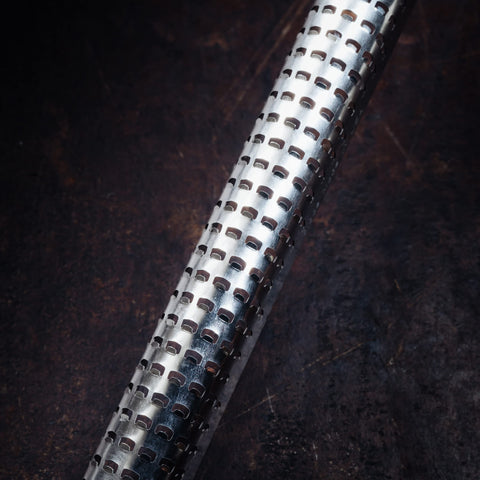 Microplane blade close-up showing razor-sharp edges for flavor release.