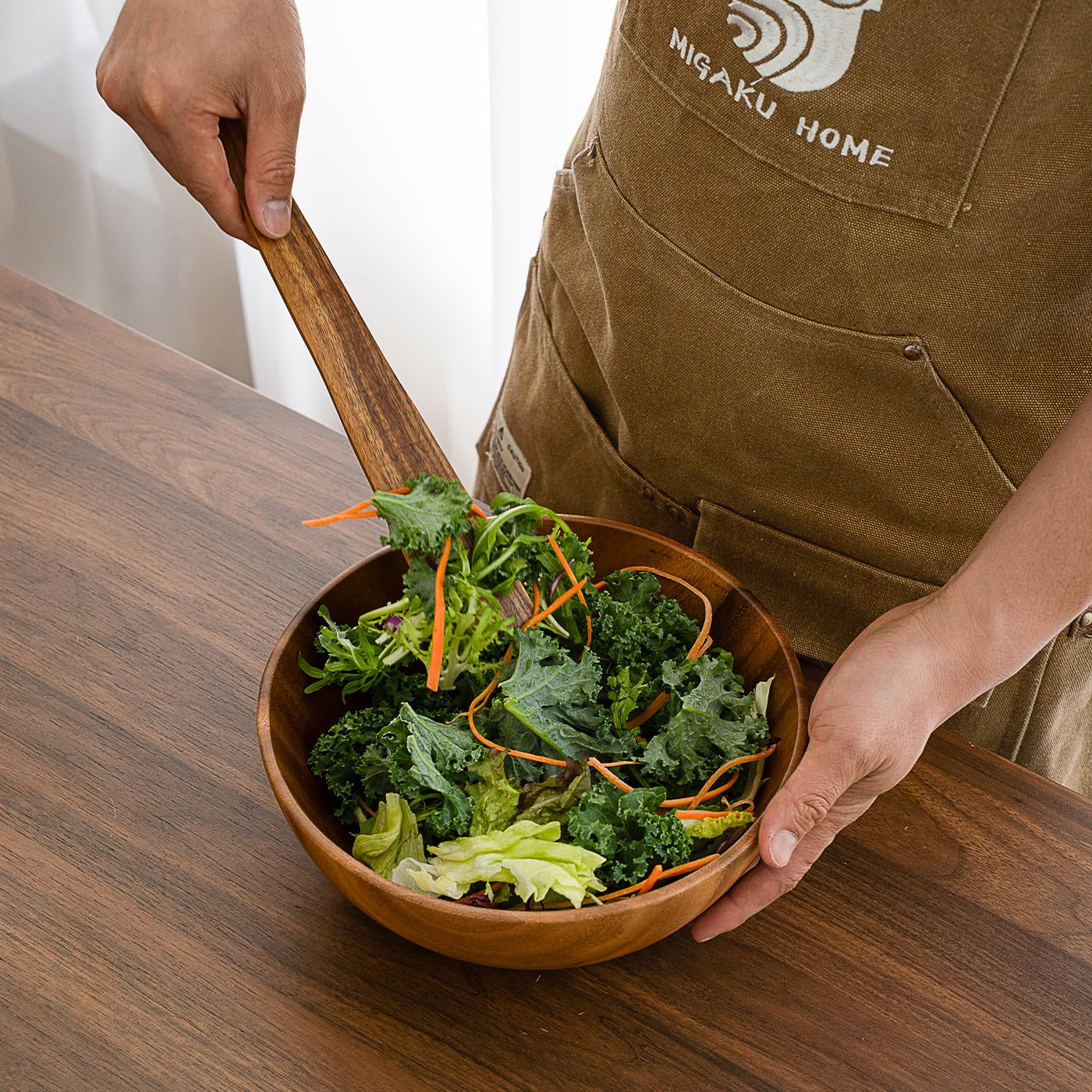 Migaku Home acacia spatula helps crush garlic on a cutting board