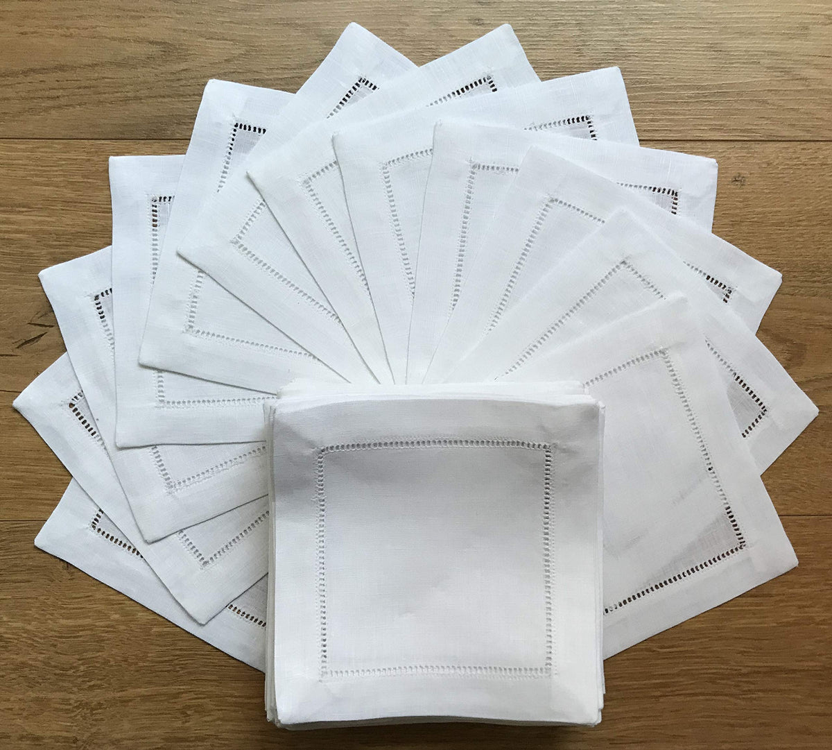Minhcraft white linen napkins with ladder-hemstitch stacked for elegant service.