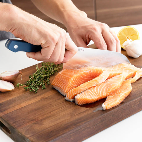 Misen Santoku knife in hand cutting vegetables demonstrates kitchen versatility.