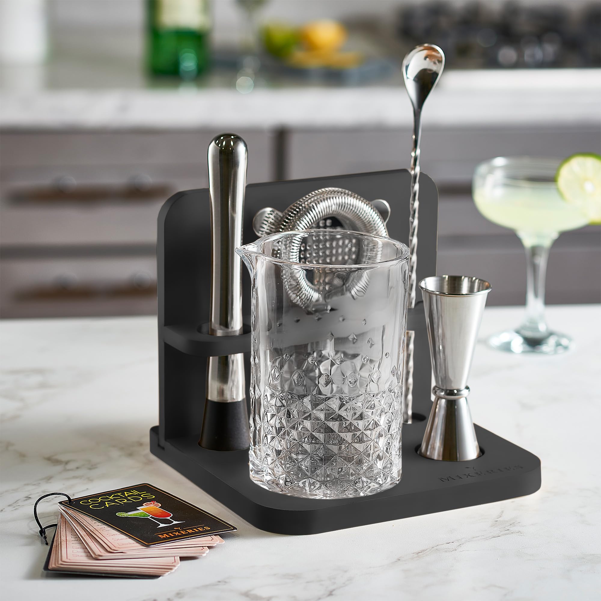 Mixeries bamboo stand organizes bar tools on a stylish home bar setup.