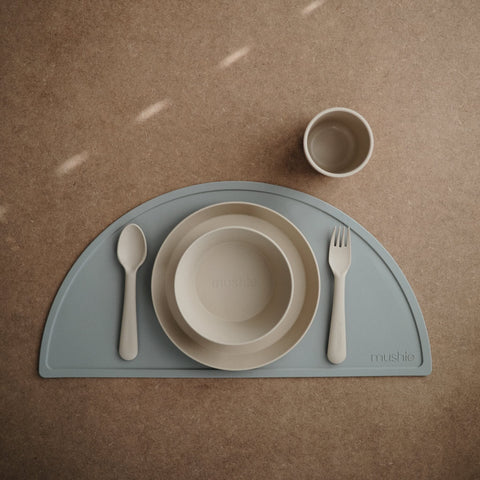 Mushie ivory cups in a mealtime scene, kid-friendly design.