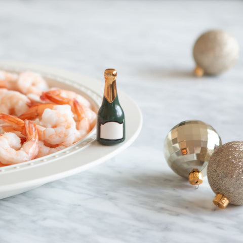 Nora Fleming champagne bottle mini on a dinner table adding sparkling flair