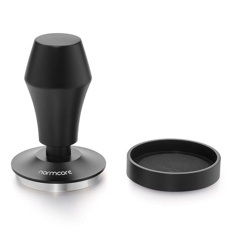 Normcore 58.5mm tamper V4 leveling plate aligned on a filter basket for level tamping.