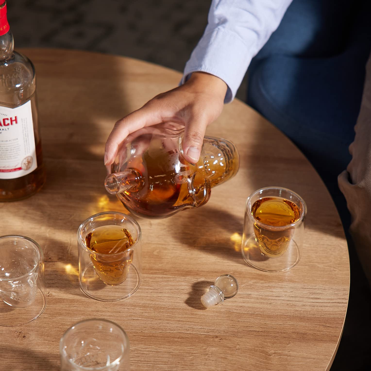 Six skull glasses showcased with the decanter for entertaining.
