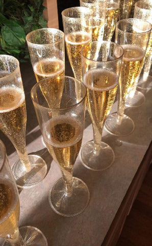 Oojami gold glitter detail adds festive shine to party champagne flutes.