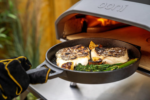 Ooni skillet used over open fire for versatile outdoor cooking.
