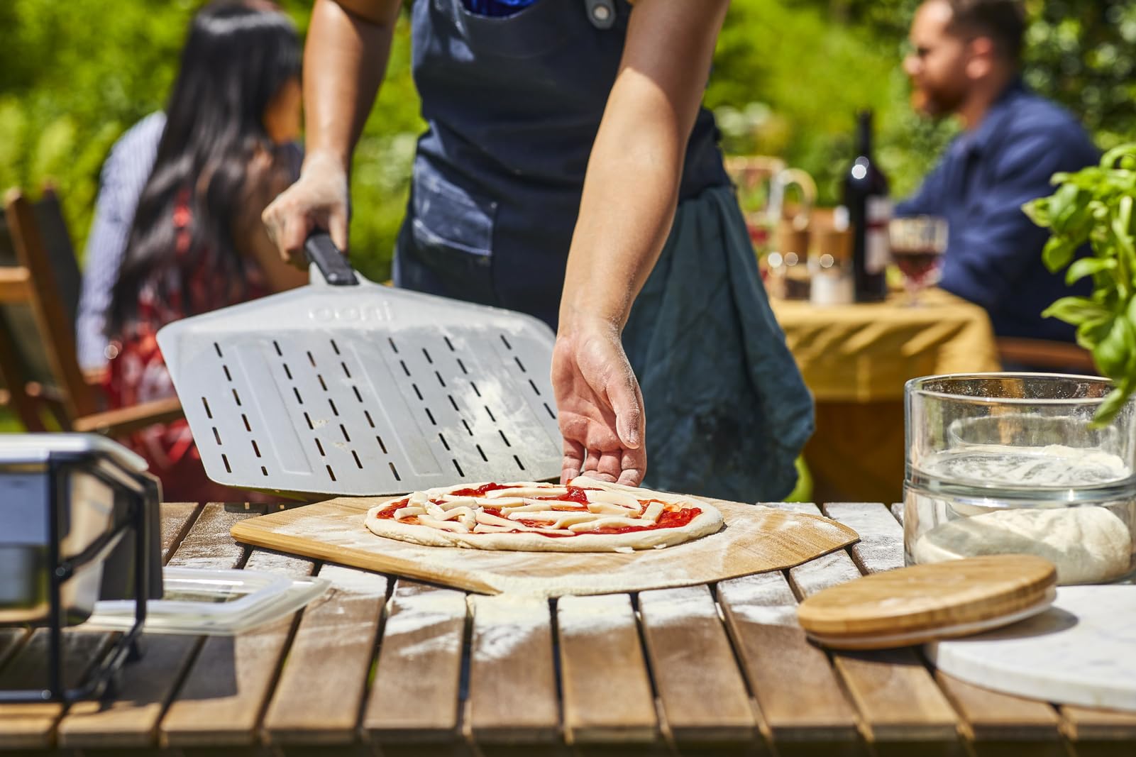 Ooni long-handle pizza peel safely keeps hands away from heat.