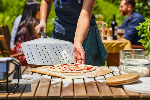 Ooni long-handle pizza peel safely keeps hands away from heat.