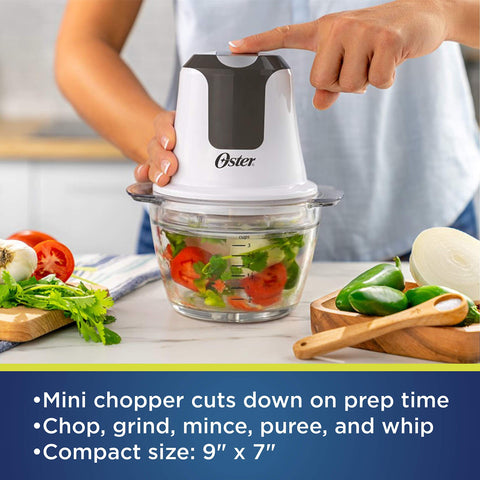 Oster mini chopper with dual stainless steel blades for versatile chopping and grinding.