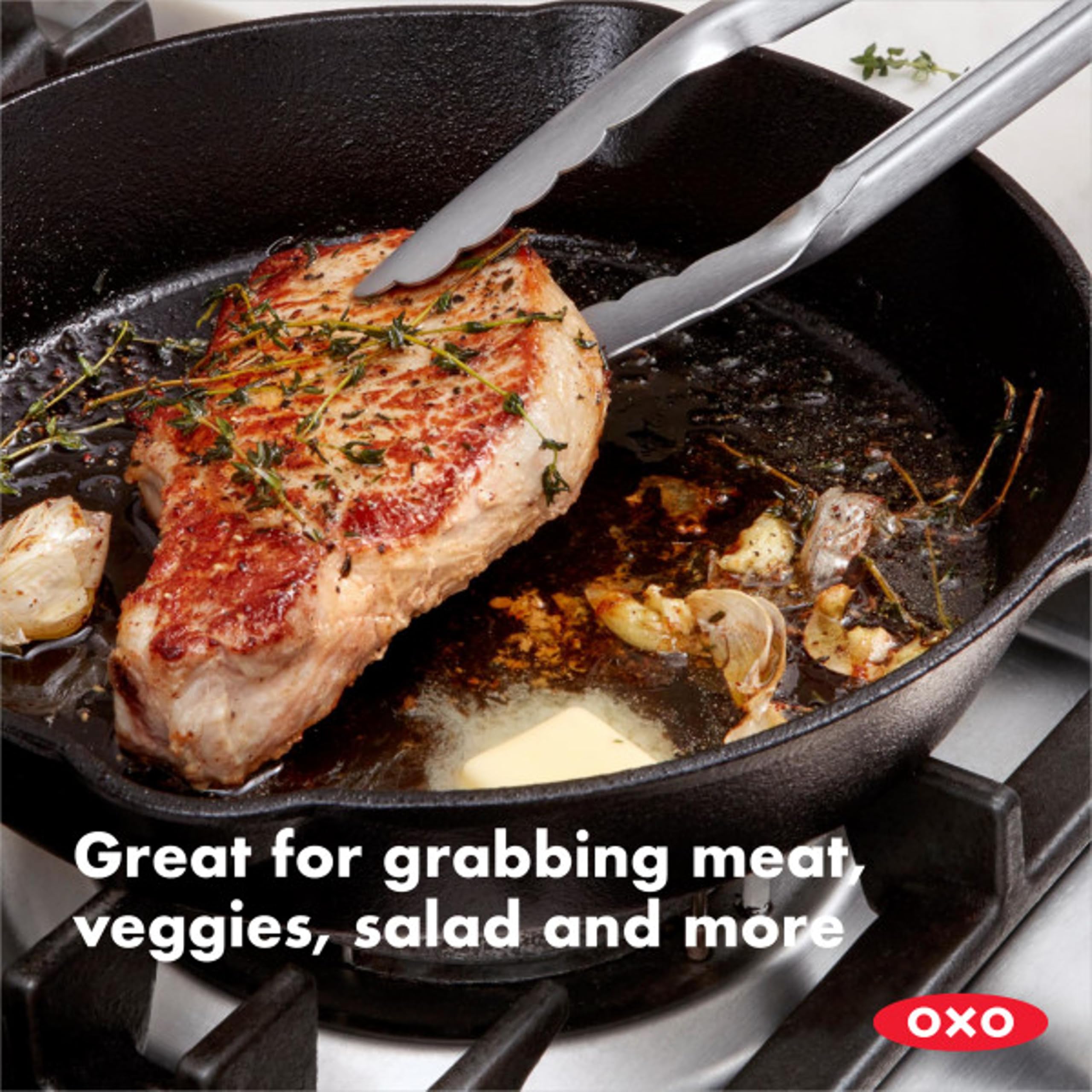 OXO Good Grips 12-inch tongs with scalloped edges securely holding food.