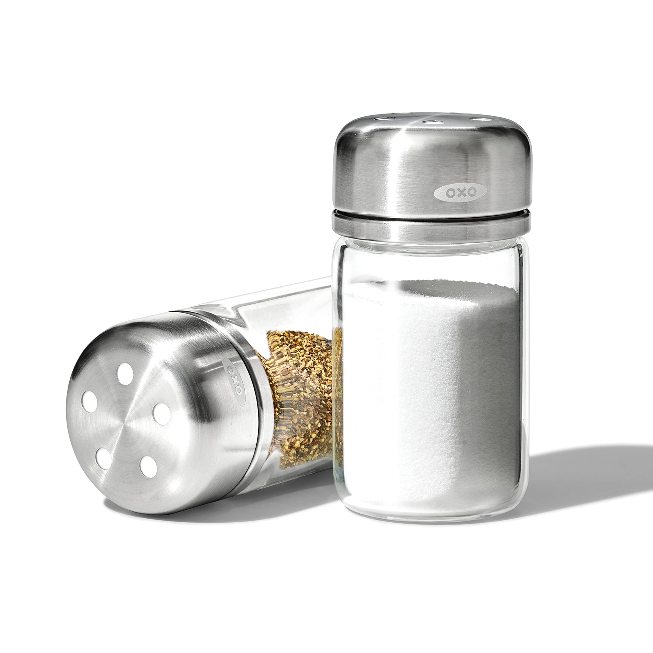 OXO Good Grips glass shaker set with clear bodies and 3.5 oz capacity for salt and pepper.