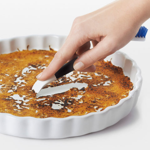 OXO Good Grips flat scraper slides under surfaces to lift messes
