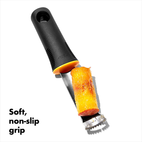 In-use shot showing OXO Peach Pitter on peach slice for pitting