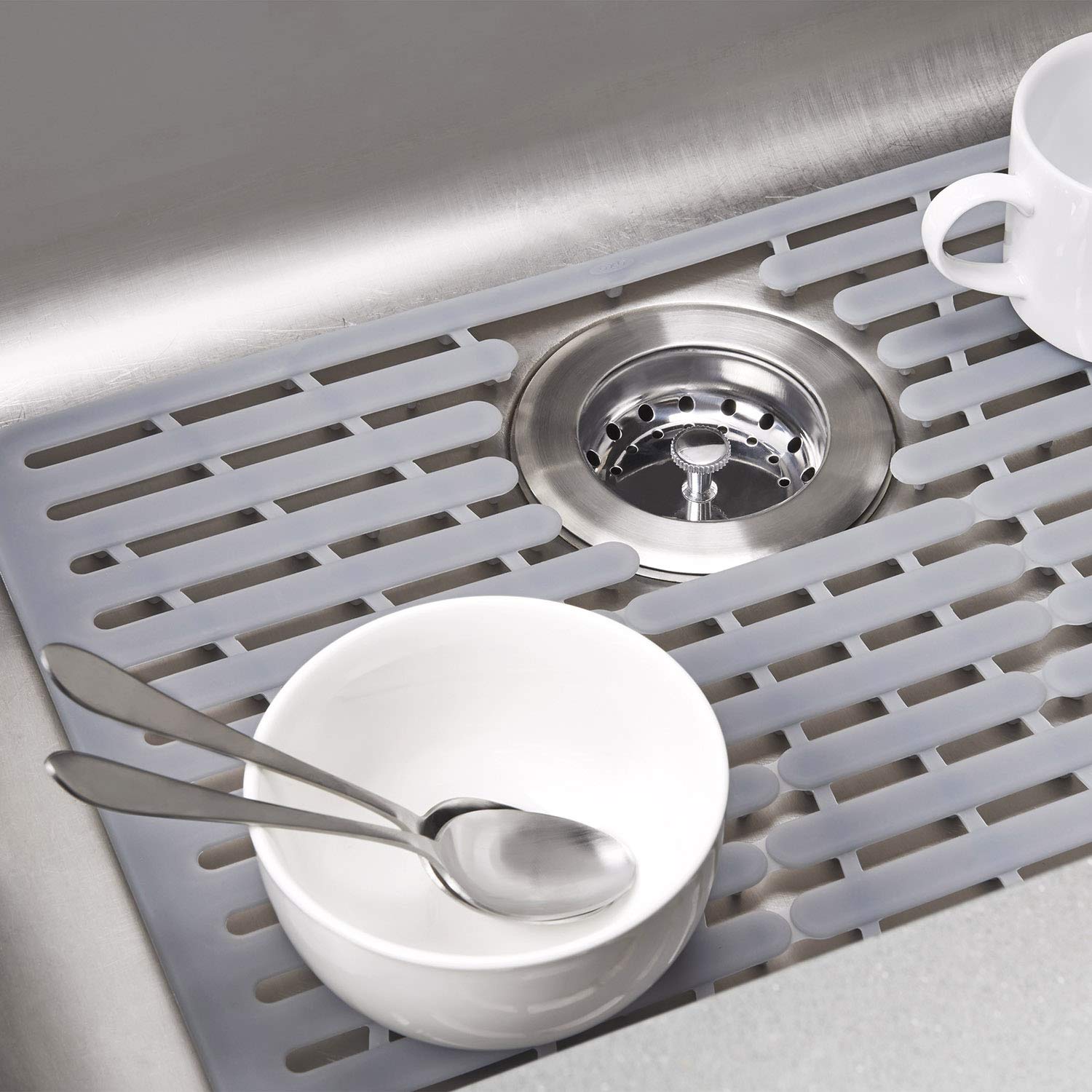 OXO Good Grips silicone sink mat showing heat-safe and dishwasher-safe use.