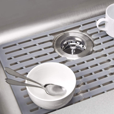 OXO Good Grips silicone sink mat showing heat-safe and dishwasher-safe use.