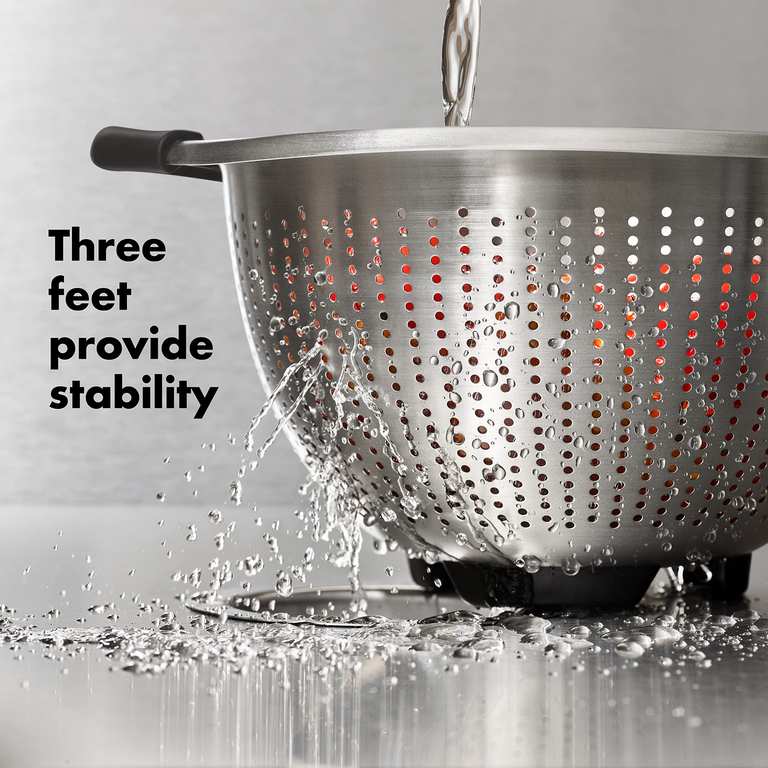 OXO Good Grips colander with three feet for stable sink use.