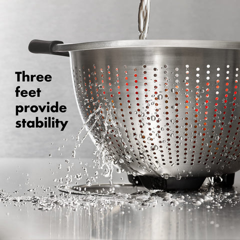 OXO Good Grips colander with three feet for stable sink use.