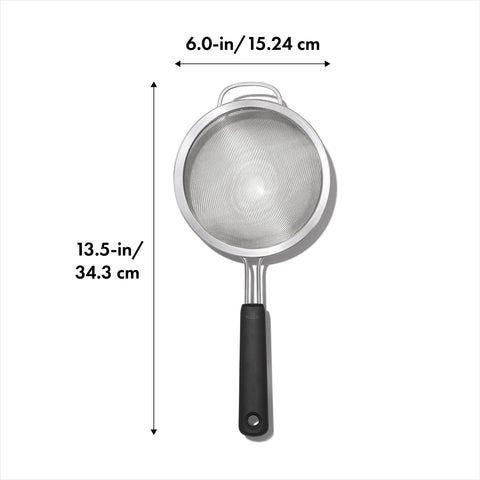 OXO Good Grips strainer on a bowl, showing the secure loop and sturdy design for rinsing.