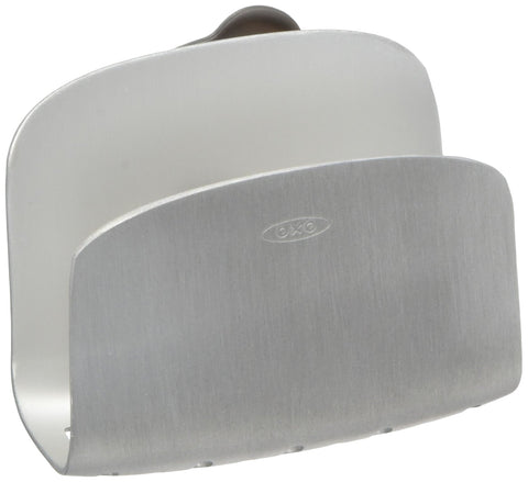 OXO suction sponge holder mounted on sink wall for secure storage.
