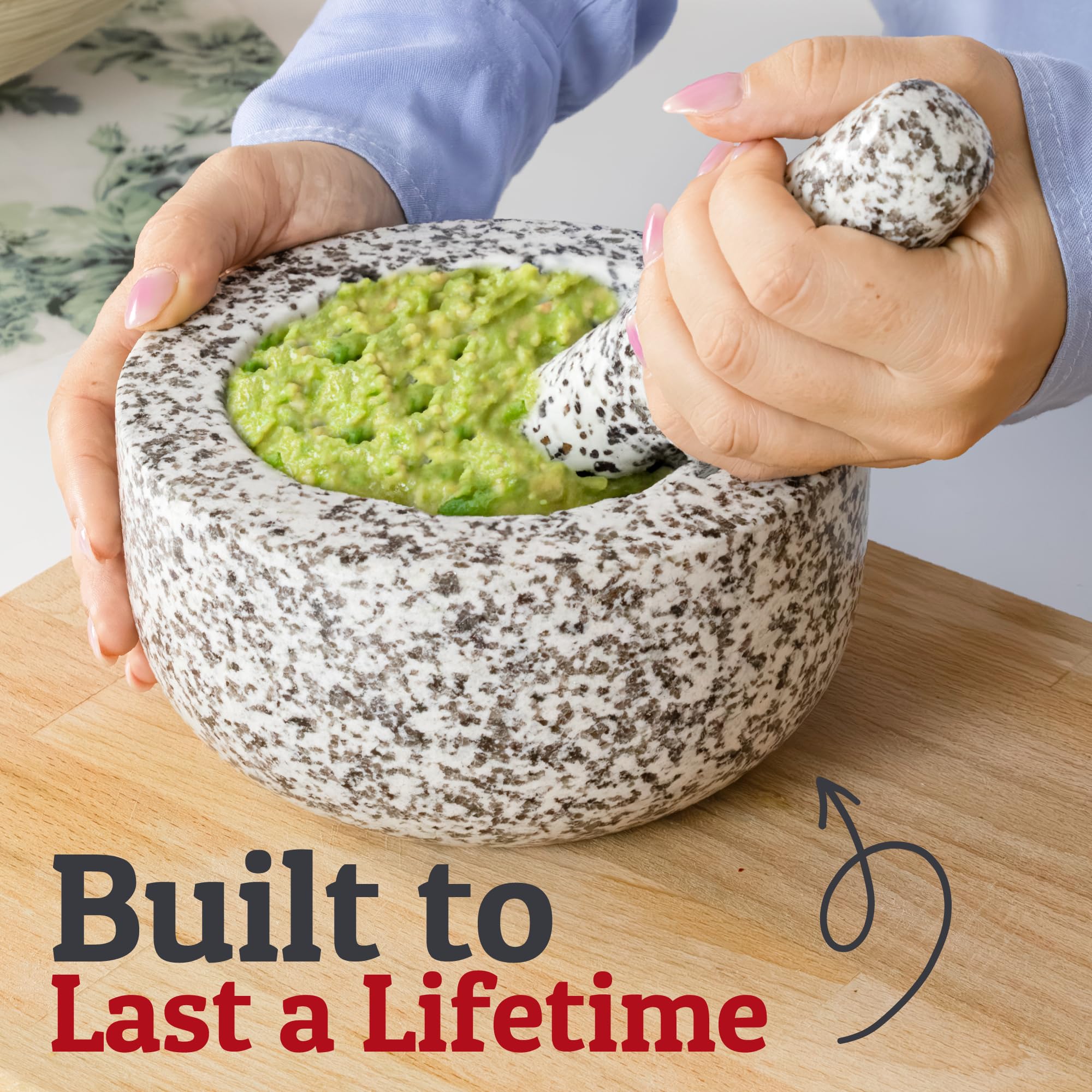 Close-up of pestle grinding fresh herbs in the granite mortar.