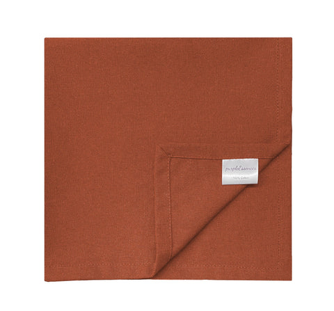 PurpleEssences rust napkins on a dining table enhance everyday meals with soft cotton touch.