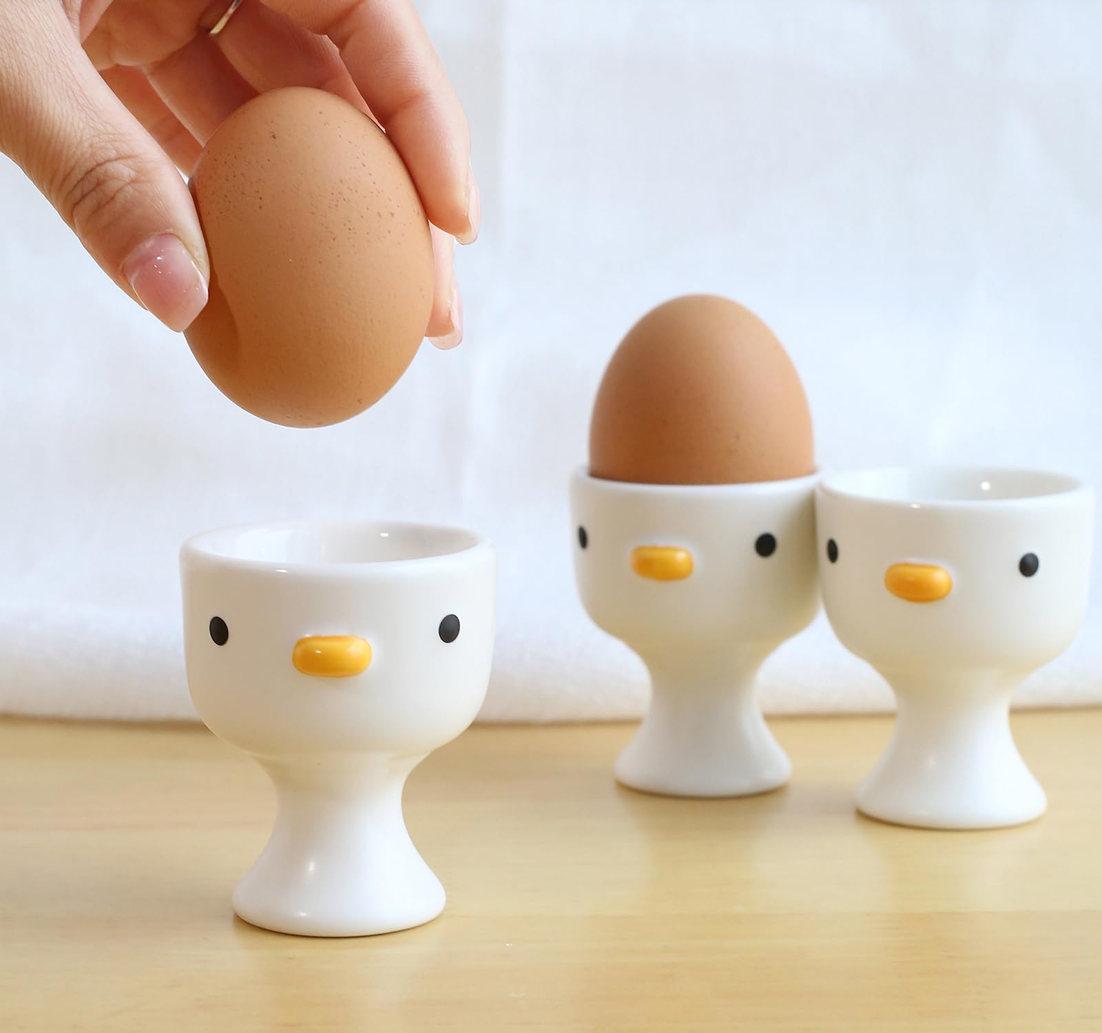 PURROOM chicken-shaped ceramic egg cups enhance table styling.